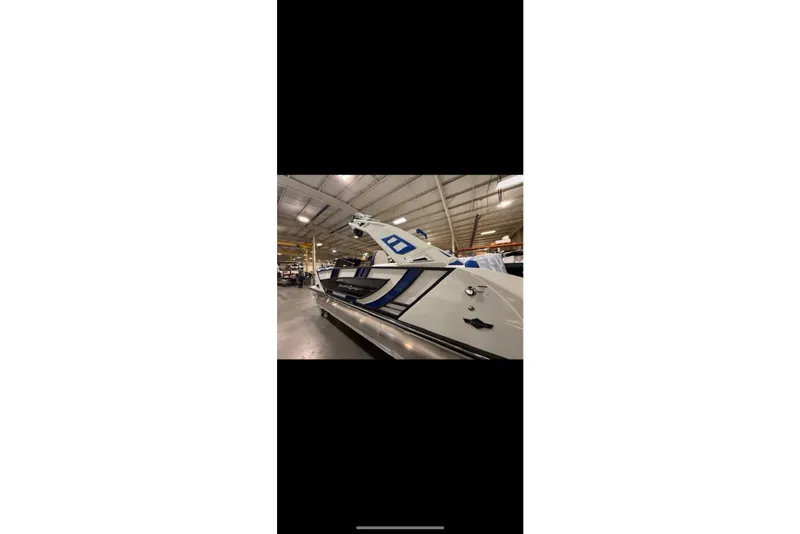 Slide: The Image of 2026 South Bay 25 Sport Twin boat in a warehouse setting. - 30