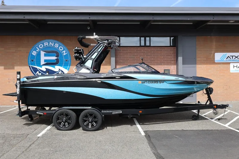 The Image of 2021 Centurion Fi23 boat on trailer, parked outside Bjornson Marine building. - 1