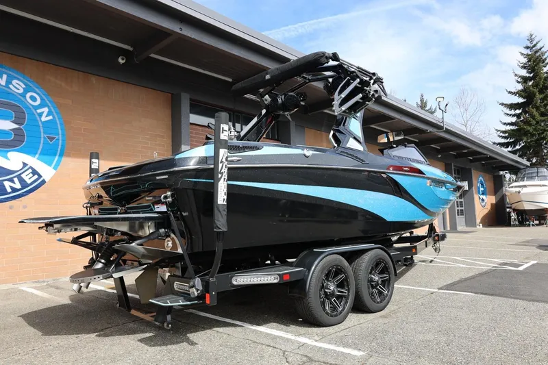 Slide: The Image of 2021 Centurion Fi23 boat on trailer outside dealership, showcasing sleek design and vibrant colors. - 15