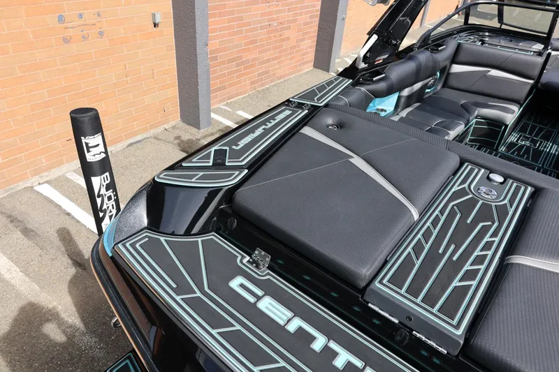 Slide: The Image of 2021 Centurion Fi23 boat interior with sleek black and teal design, parked outdoors. - 17