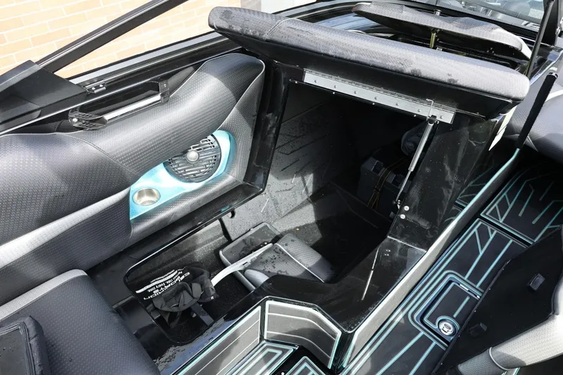 Slide: The Image of Interior of a 2021 Centurion Fi23 boat, featuring storage compartment and speaker. - 38