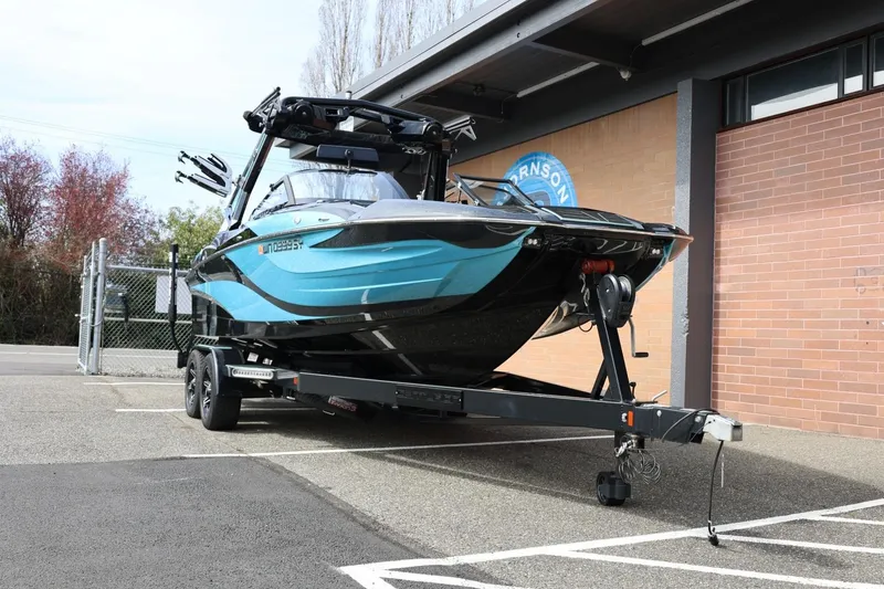 Slide: The Image of 2021 Centurion Fi23 boat on trailer, parked outside a building. - 4