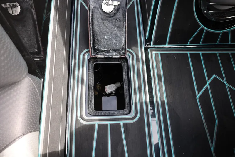 Slide: The Image of 2021 Centurion Fi23 boat storage compartment with sleek black and blue design. - 53