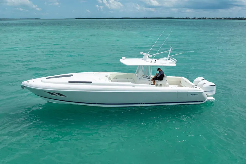 The Image of 2015 Intrepid 400 Cuddy boat cruising on turquoise waters under a clear sky. - 1