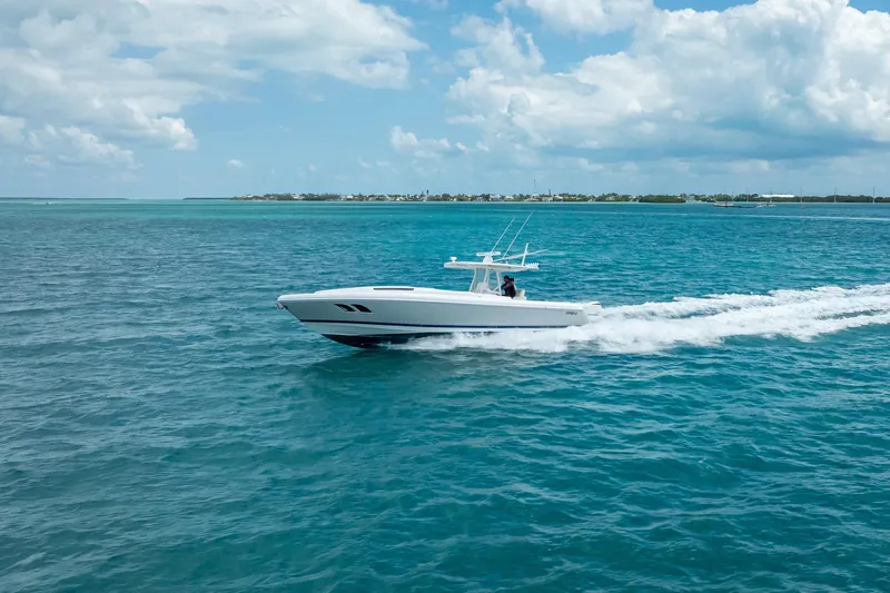 Slide: The Image of 2015 Intrepid 400 Cuddy cruising on clear blue ocean under a partly cloudy sky. - 15