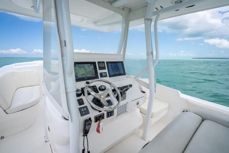 Slide: The Image of 2015 Intrepid 400 Cuddy boat interior with steering wheel and navigation screens, ocean view. - 16