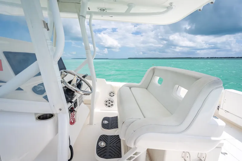 Slide: The Image of 2015 Intrepid 400 Cuddy boat interior with ocean view and white seating. - 25
