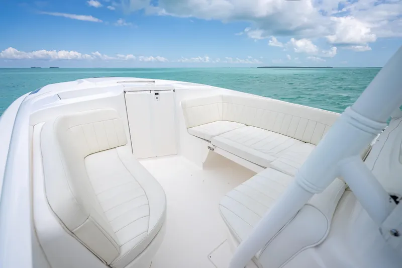 Slide: The Image of 2015 Intrepid 400 Cuddy boat interior with white seating, ocean view. - 28