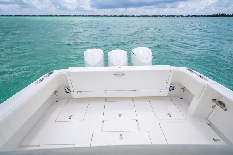 Slide: The Image of 2015 Intrepid 400 Cuddy boat deck with triple outboard engines on turquoise water. - 32
