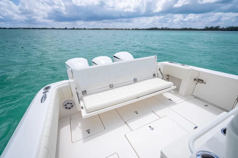 Slide: The Image of 2015 Intrepid 400 Cuddy boat with white seating, on turquoise water under cloudy sky. - 34