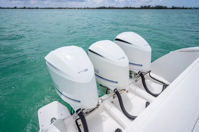 Slide: The Image of Triple Yamaha outboard engines on a 2015 Intrepid 400 Cuddy boat in turquoise waters. - 35