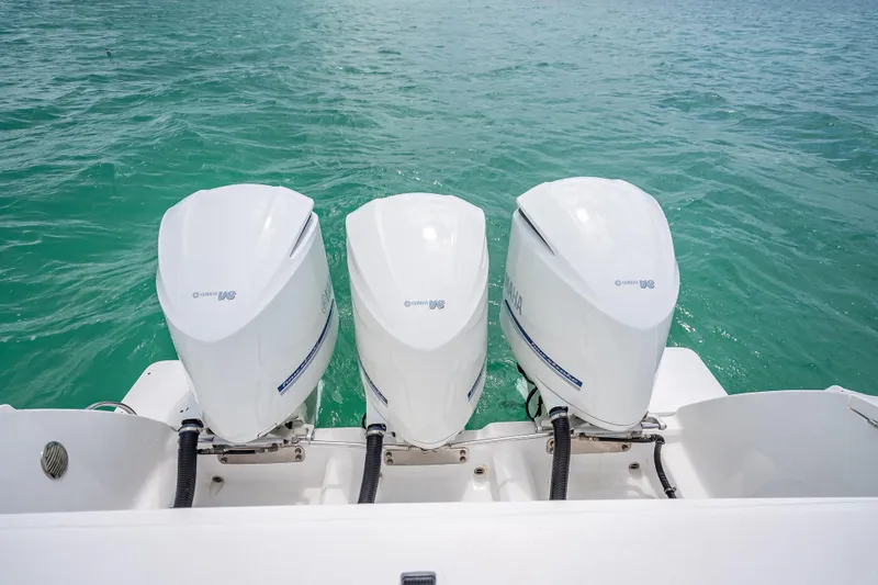 Slide: The Image of Triple Yamaha outboard engines on a 2015 Intrepid 400 Cuddy boat in turquoise water. - 36