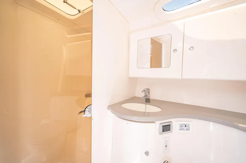 Slide: The Image of 2015 Intrepid 400 Cuddy bathroom with sink, mirror, and storage cabinets. - 47