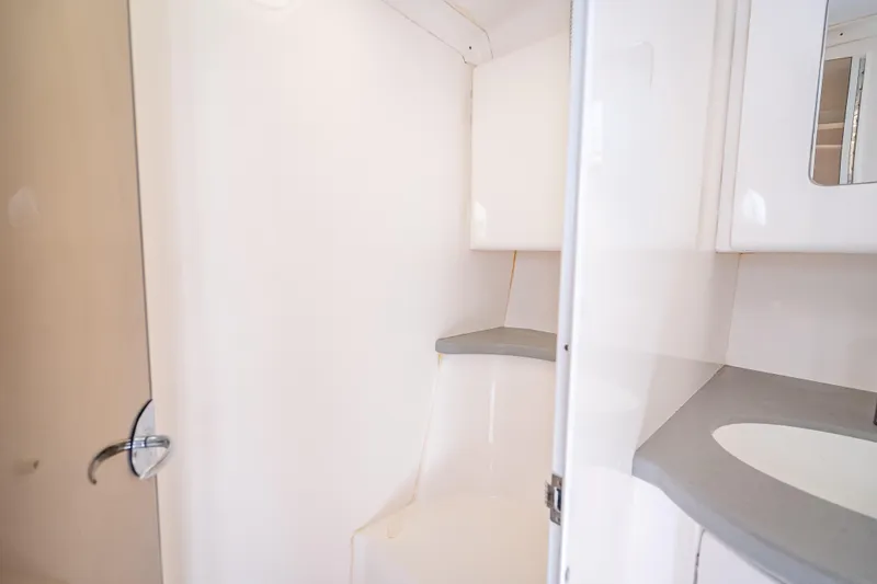 Slide: The Image of 2015 Intrepid 400 Cuddy boat interior bathroom with sleek white design. - 48
