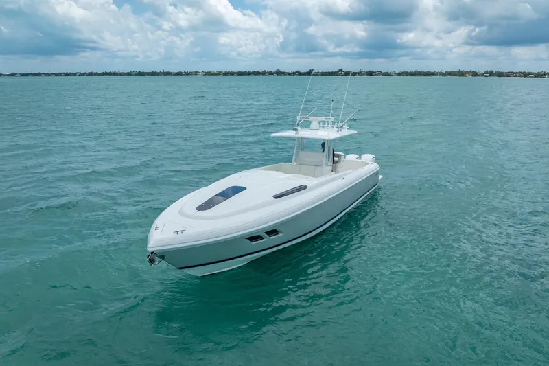Slide: The Image of 2015 Intrepid 400 Cuddy boat on calm blue ocean under cloudy sky. - 6
