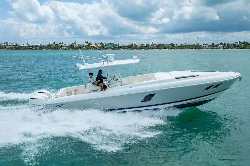 Slide: The Image of 2015 Intrepid 400 Cuddy cruising on turquoise ocean waters under a cloudy sky. - 8