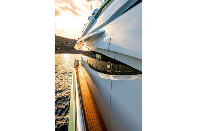 Slide: The Image of Side view of 2010 Peri Yachts 29M Custom, reflecting sunset on calm waters. - 6