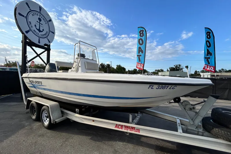 The Image of 1999 Hydra-Sports 2000 CC boat on trailer at dealership with sale banners. - 0