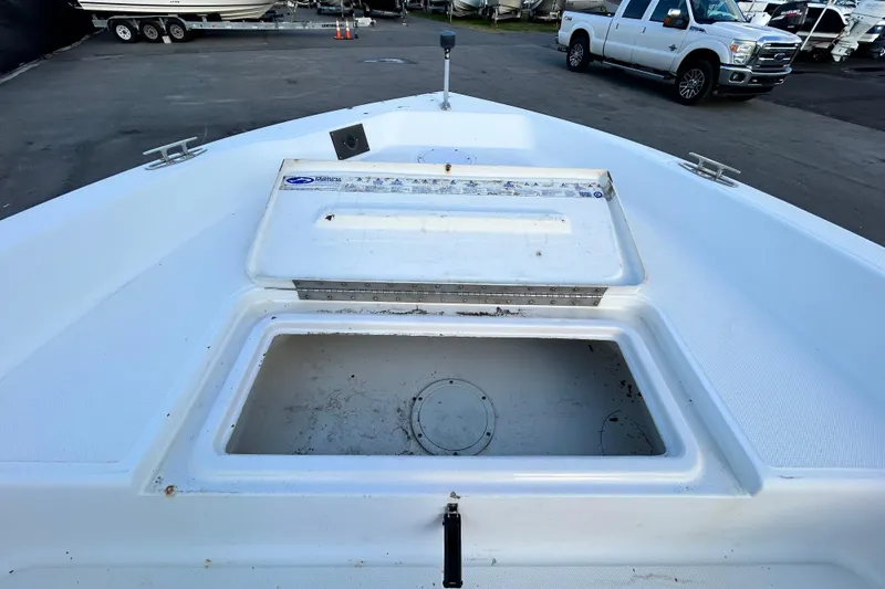 Slide: The Image of 1999 Hydra-Sports 2000 CC boat deck with storage compartment, parked near vehicles. - 32