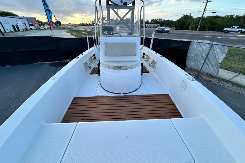 Slide: The Image of 1999 Hydra-Sports 2000 CC boat with wooden deck, docked near a road. - 37