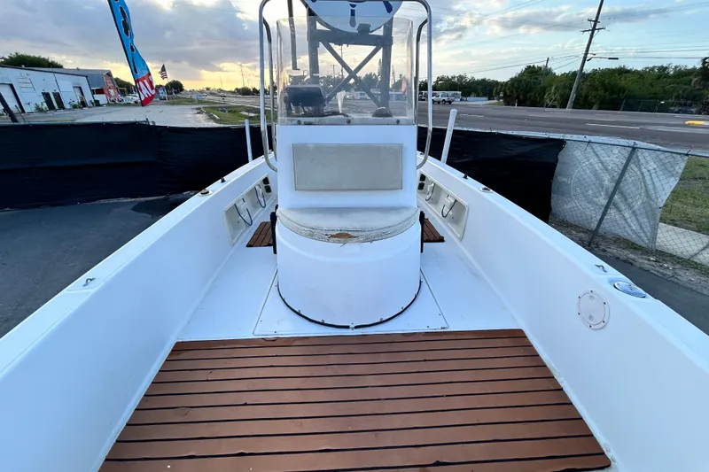 Slide: The Image of 1999 Hydra-Sports 2000 CC boat with wooden deck, docked near a road. - 38