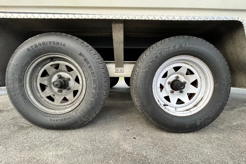 Slide: The Image of Trailer wheels of a 1999 Hydra-Sports 2000 CC boat on pavement. - 58