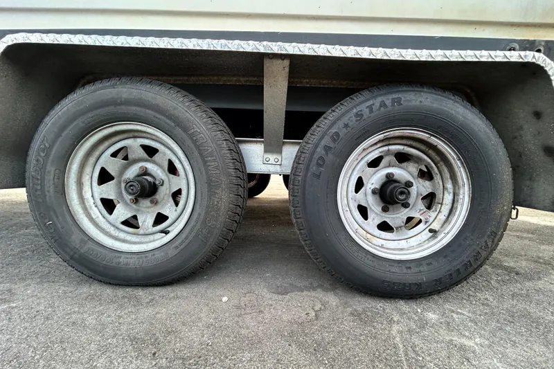 Slide: The Image of Trailer wheels of a 1999 Hydra-Sports 2000 CC boat on pavement. - 59