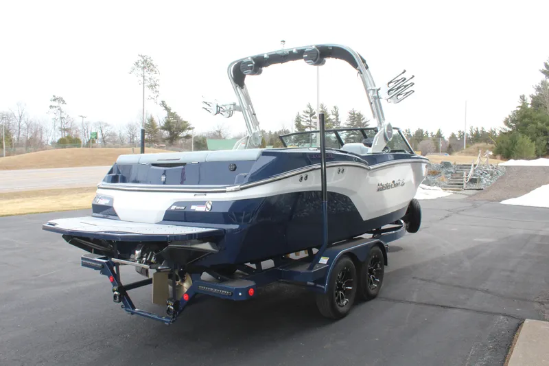Slide: The Image of 2026 MasterCraft NXT23 boat on trailer, blue and white design. - 5