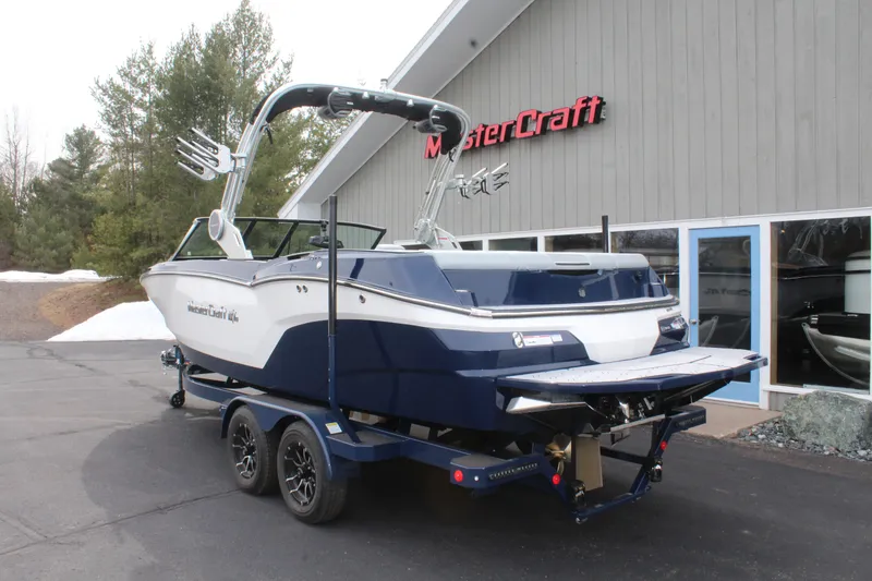 Slide: The Image of 2026 MasterCraft NXT23 boat on trailer outside showroom. - 6
