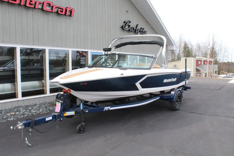 Slide: The Image of 2026 MasterCraft ProStar boat on trailer in front of building. - 3