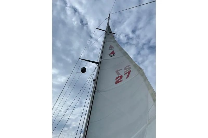 Slide: The Image of Sailboat mast and sail against cloudy sky, Bristol 38.8, 1983 model. - 10