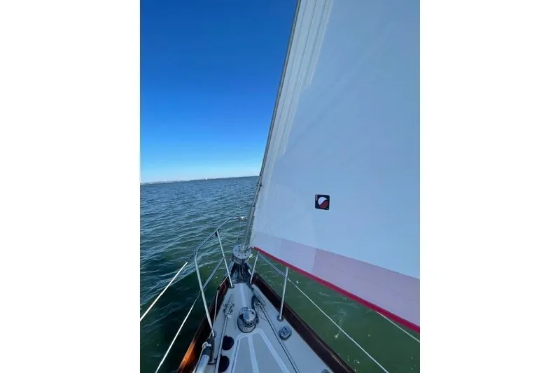 Slide: The Image of Sailboat mast and sail against cloudy sky, Bristol 38.8, 1983 model. - 13