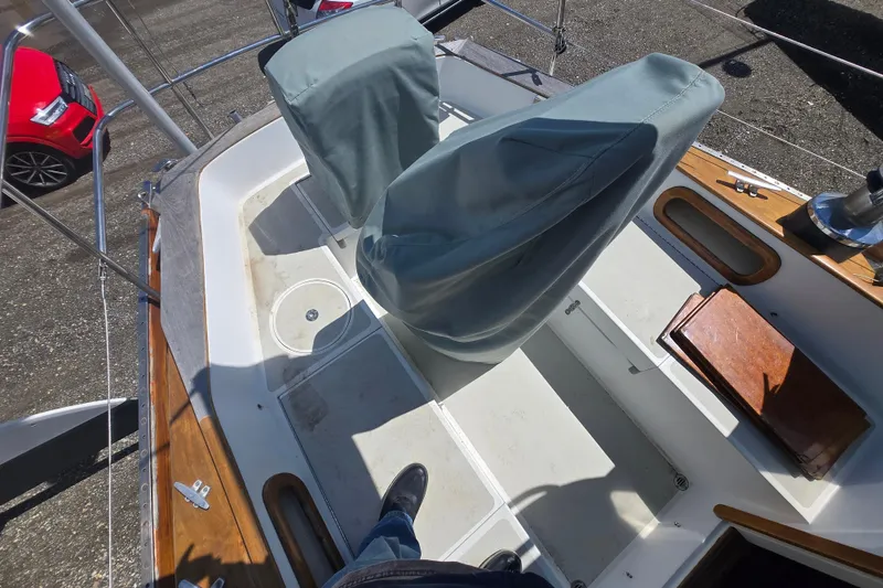 Slide: The Image of Cockpit of a 1983 Bristol 38.8 sailboat with covered seats and wooden accents. - 16