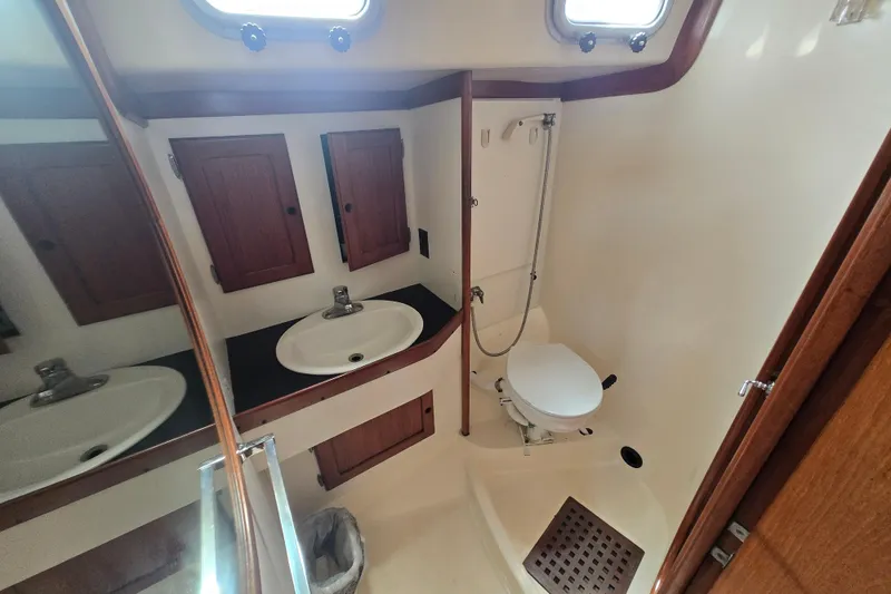 Slide: The Image of 1983 Bristol 38.8 yacht bathroom with sink, toilet, and wooden cabinets. - 17