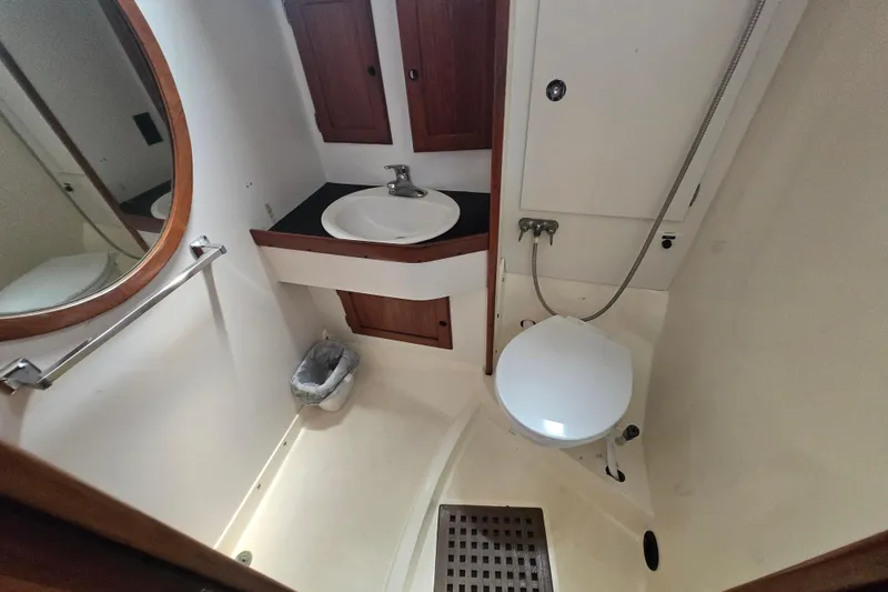 Slide: The Image of Compact bathroom in a 1983 Bristol 38.8 yacht with sink, toilet, and wooden cabinetry. - 18
