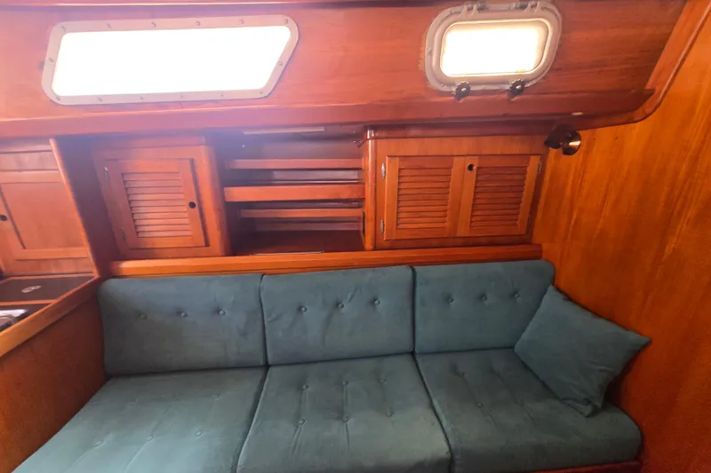Slide: The Image of 1983 Bristol 38.8 yacht interior with teal sofa and wooden cabinetry. - 19