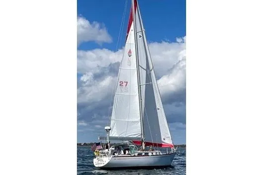 Slide: The Image of 1983 Bristol 38.8 sailboat on open water under a partly cloudy sky. - 2