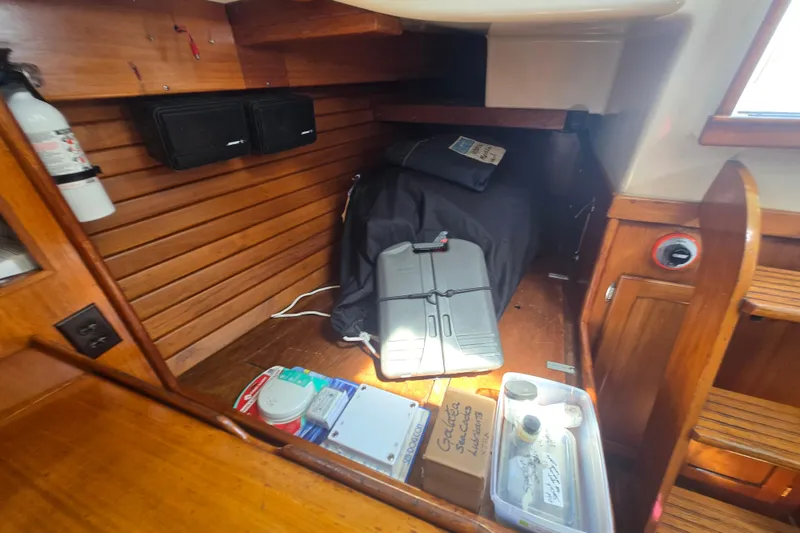 Slide: The Image of Interior of a 1983 Bristol 38.8 sailboat with wooden paneling and storage items. - 21