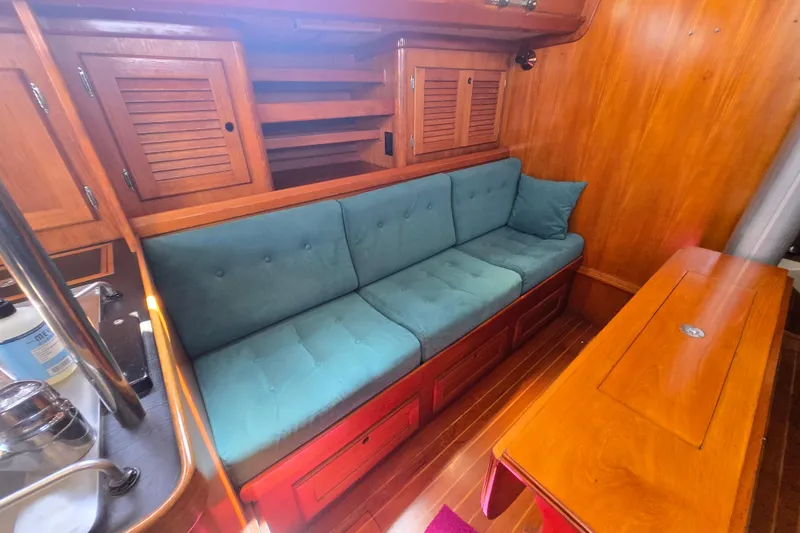 Slide: The Image of Interior of a 1983 Bristol 38.8 sailboat with teal cushions and wooden cabinetry. - 22