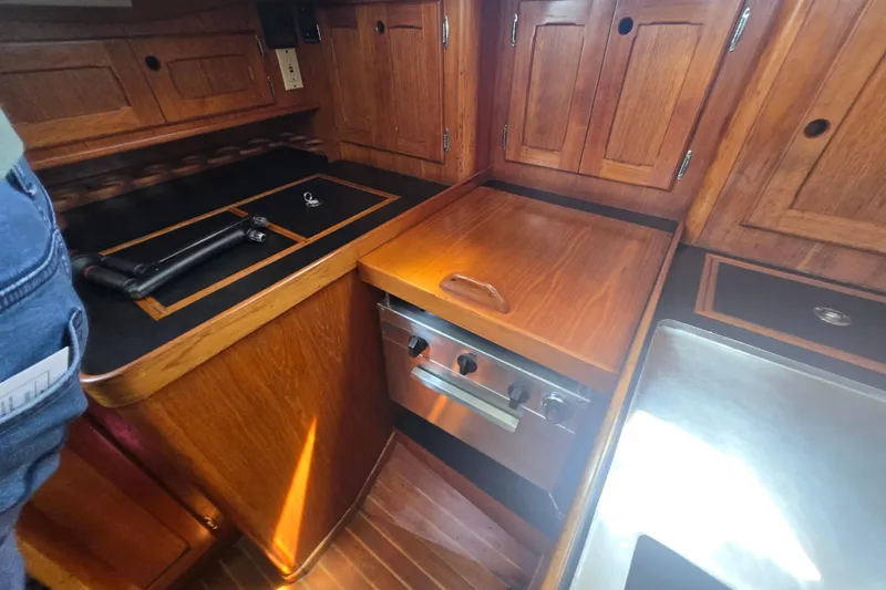 Slide: The Image of 1983 Bristol 38.8 yacht interior kitchen with wooden cabinetry and stainless steel appliances. - 24