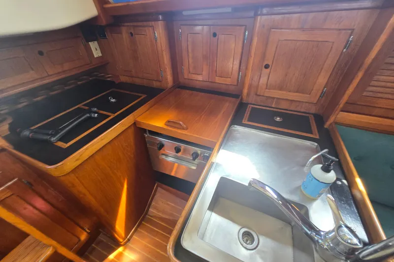 Slide: The Image of 1983 Bristol 38.8 yacht kitchen with wooden cabinets, stove, and sink. - 25