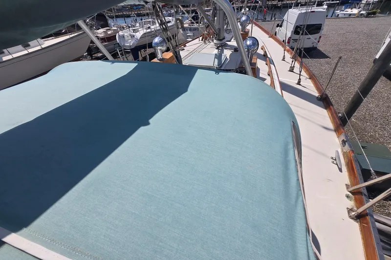 Slide: The Image of 1983 Bristol 38.8 sailboat deck with blue cover, docked at marina. - 26