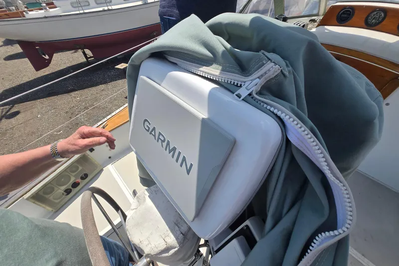 Slide: The Image of Garmin navigation system on a 1983 Bristol 38.8 sailboat, partially covered, with a person nearby. - 27