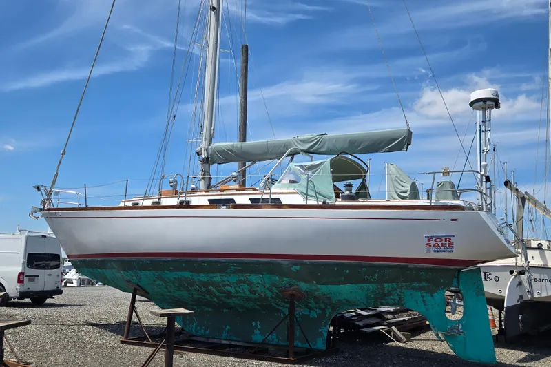 Slide: The Image of 1983 Bristol 38.8 sailboat for sale, displayed on land under a clear blue sky. - 31