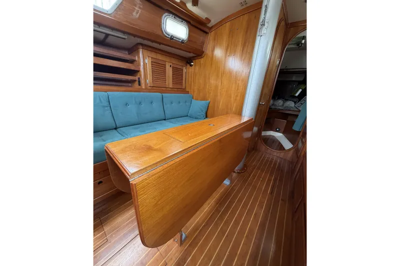 Slide: The Image of Interior of 1983 Bristol 38.8 sailboat with wooden table and blue cushioned seating. - 34