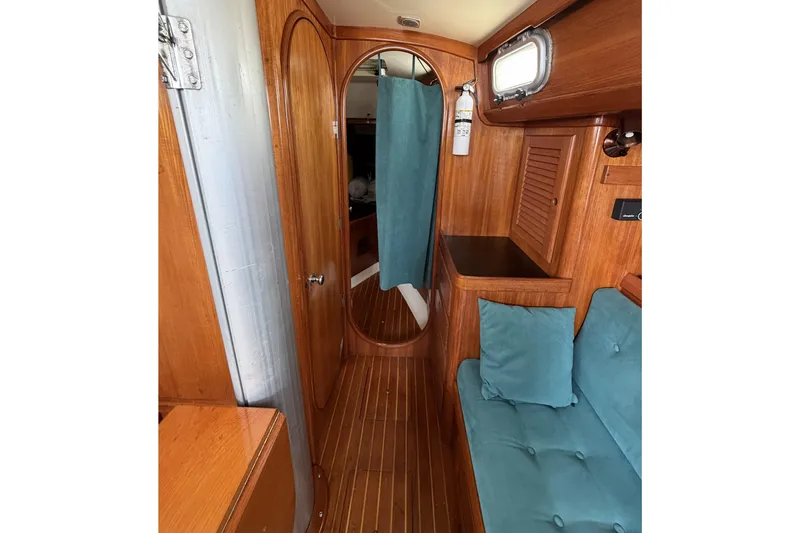 Slide: The Image of Interior of 1983 Bristol 38.8 sailboat with wooden paneling and teal cushions. - 35