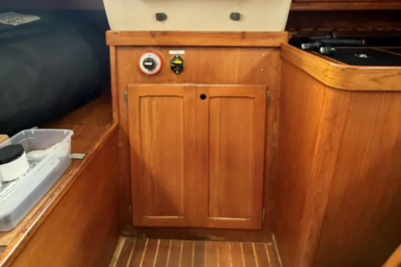 Slide: The Image of Wooden interior of a 1983 Bristol 38.8 sailboat, featuring a cabinet and control panel. - 40