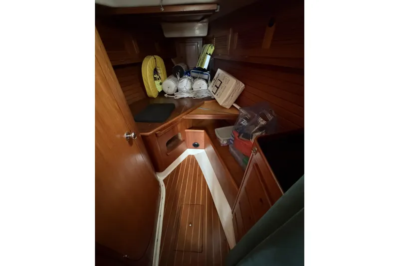 Slide: The Image of Interior of 1983 Bristol 38.8 sailboat with wooden paneling and storage items. - 42