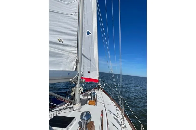 Slide: The Image of Sailing on a 1983 Bristol 38.8 yacht with white sails against a clear blue sky. - 6