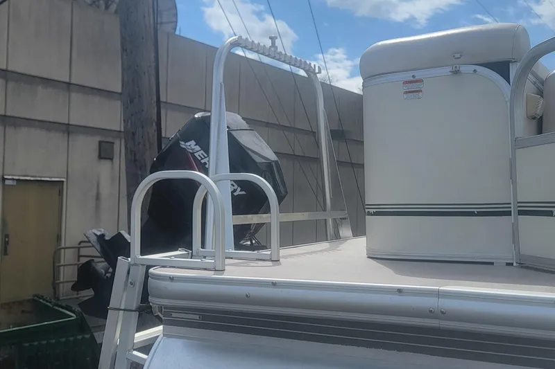 Slide: The Image of 2011 Sun Tracker Party Barge 20 Classic Series with Mercury outboard motor, docked outdoors. - 13